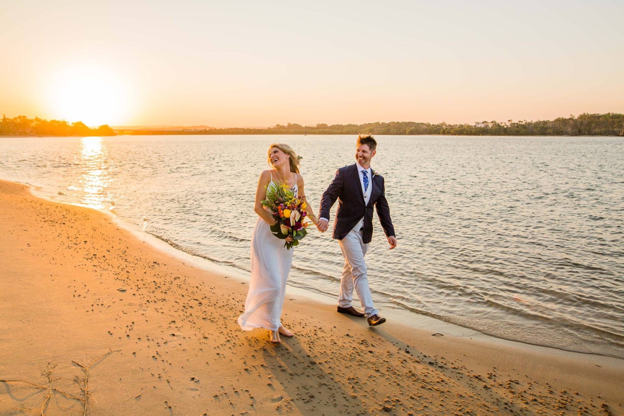 Couple walking on the beach at sunset